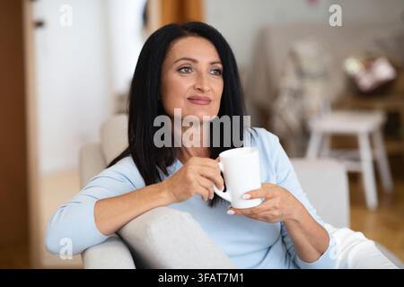 Porträt von lächelnden reifen Frau trinken heißen Kaffee Stockfoto