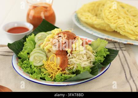 Rujak Juhi Asinan Jakarta. Traditioneller indonesischer Salat aus gelben Nudeln, Gemüse und gegrillten Tintenfisch-Krackern mit Erdnuss-Dressing Stockfoto
