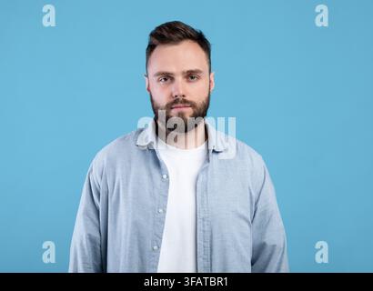 Porträt von ernst jungen Kerl Blick auf Kamera auf blau studio-Hintergrund Stockfoto