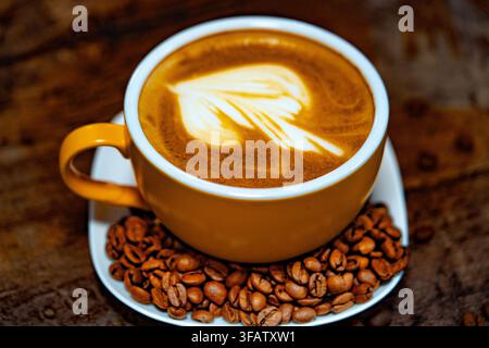Tasse Kaffee dekoriert mit Herz und Kaffeebohnen transparenter dunkler Hintergrund Stockfoto