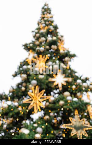 Schmückter Weihnachtsbaum mit leuchtenden goldenen Sternen auf weißem Hintergrund Stockfoto