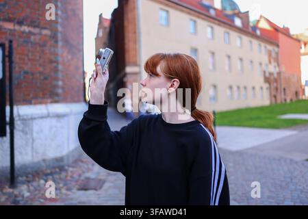 Junge Frau Reisende macht Fotos mit einer kompakten Digitalkamera, während sie historische Architektur in einer europäischen Stadt erkundet. Stockfoto