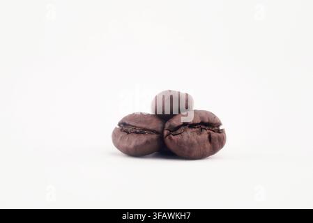 Haufen aromatischer gerösteter Kaffeebohnen isoliert auf einem sauberen weißen Hintergrund, Morgenenergie und Espresso-Getränkekonzept. Stockfoto