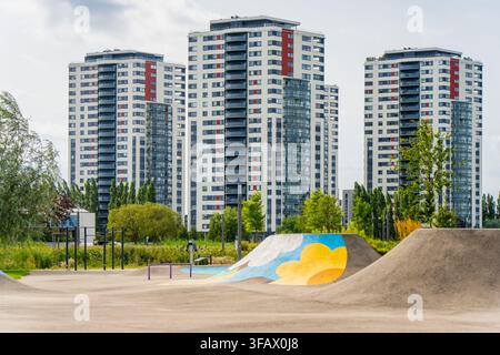 Wohnhochhäuser, die sich hinter einem modernen Stadtpark mit Erholungs-Pump-Track-Anlagen und Grünflächen befinden Stockfoto