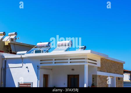 Nahaufnahme eines mediterranen Hauses mit Olympic Sun-Solarwarmwasserbereitern auf dem Dach. Griechenland. Kreta. Stockfoto