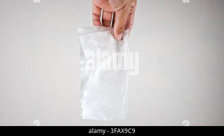 Mann, der ein benutztes Taschentuch aufhebt Stockfoto