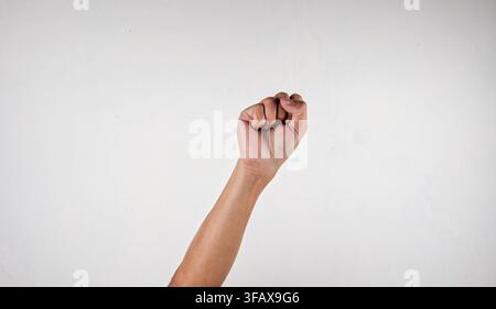 Asiatischer Mann, der seine Faust auf isoliertem Hintergrund erhebt Stockfoto