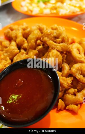 Knusprige gebratene Tintenfischringe, gebratenes Meeresfrüchtegericht mit roter Chili-Dip-Sauce Stockfoto