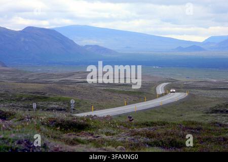 Winding asphaltstraße durch eine felsige, vulkanische Landschaft nahe Þingvellir entlang der Route 36 im Südwesten Islands, Teil der Goldenen Kreisroute Stockfoto
