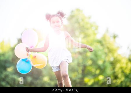 Mädchen mit Luftballons laufen. Stockfoto