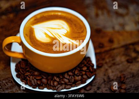 Tasse Kaffee dekoriert mit Herz und Kaffeebohnen transparenter dunkler Hintergrund Stockfoto