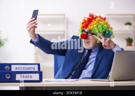 Alter Geschäftsmann, Clown, der im Büro arbeitet Stockfoto