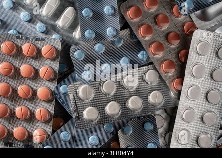 Top-Down-Ansicht, Nahaufnahme, Texturrückgrund gefüllt mit verschiedenen medizinischen Pillen, Tabletten und Kapseln in silbernen und blauen Blisterpackungen Stockfoto