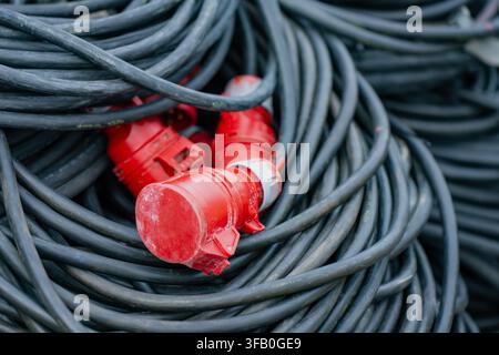 Industrielle Drehstrom-Stromkabelrolle mit einem roten robusten Steckverbinder für die vorübergehende Hochspannungsstromverteilung Stockfoto