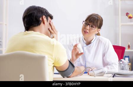 Der junge Arzt überprüft den Blutdruck der Patienten Stockfoto