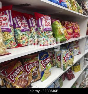 Regale gefüllt mit bunten Tüten Popcorn und Chips in einem Laden Stockfoto