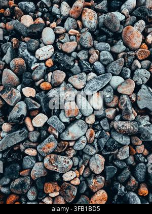 Oberblick-Textur von glatten bunten Kieselsteinen und Flusssteinen als Vollbild-Hintergrundtapete. Stockfoto