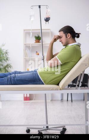 Junger Mann wartet auf den Arzt in der Klinik Stockfoto