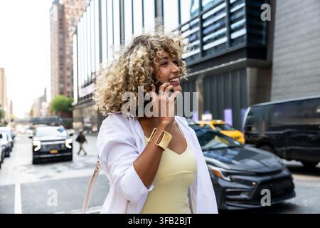 Junge Frau telefoniert auf der Straße in Manhattan Stockfoto
