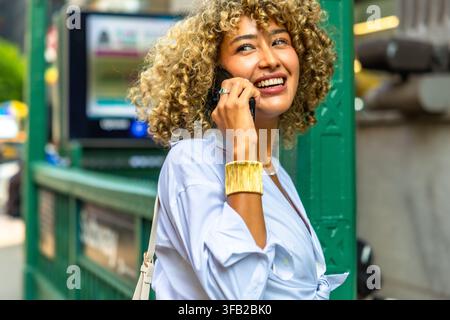 Junge Frau genießt den Lebensstil, während sie in New York City telefoniert Stockfoto