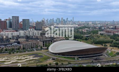 Luftbild des Queen Elizabeth Olympic Park mit dem Velodrom, dem London Aquatics Centre, moderner Wohnbebauung und der entfernten Skyline von Canary Wharf. Stockfoto