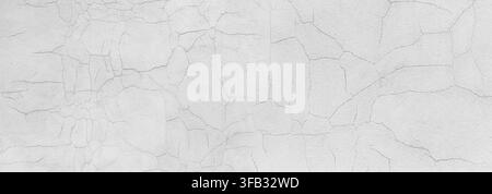 Weiße Betonwand mit vielen kleinen Rissen und einer abgenutzten, gealterten Textur Stockfoto