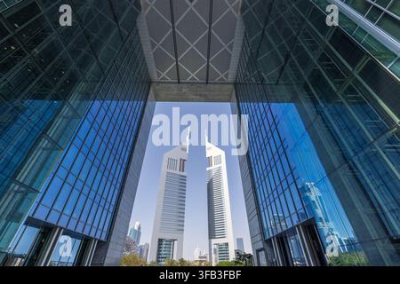 Panoramablick auf das Geschäftsviertel von Downtown Dubai in den VAE, mit ikonischen Wolkenkratzern, die von reflektierenden Glastürmen unter einem klaren blauen Himmel eingerahmt werden. Stockfoto