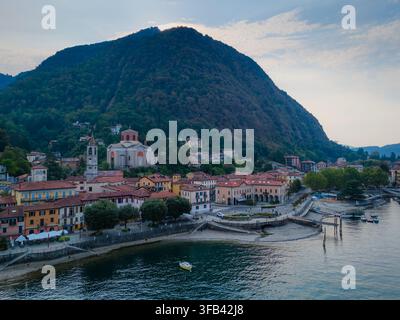 Drohnenaufnahme von Laveno-Mombello am Ufer des Lago Maggiore in Italien, mit malerischer Uferlandschaft und Alpenbergen Stockfoto