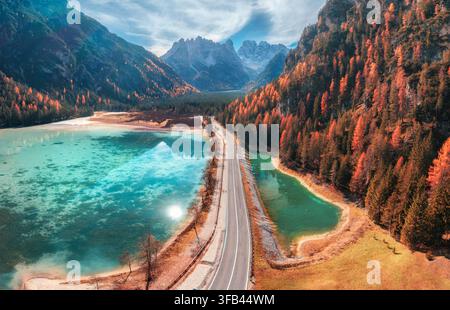 Luftbilddrohnenaufnahme einer Straße entlang eines türkisfarbenen Algensees im Herbst Stockfoto