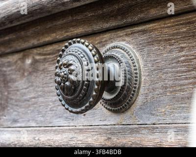 Antiker verzierter Metall-Türgriff an einer alten Holztür Stockfoto
