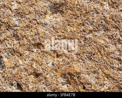alte Wand aus orangefarbenem armenischem Tuffstein, Nahaufnahme der alten Kirche des Klosters Hovhannavank in Armenien, vom Sonnenlicht beleuchtet Stockfoto