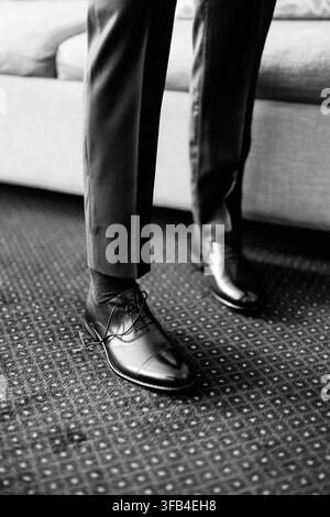 Mann in formeller Kleidung mit Anzugschuhen im Innenraum Stockfoto