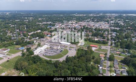 Breite Luftaufnahme von Madisonville, Kentucky, die die Innenstadt, Wohngebiete, Straßen und die umliegende baumbedeckte Landschaft zeigt. Stockfoto