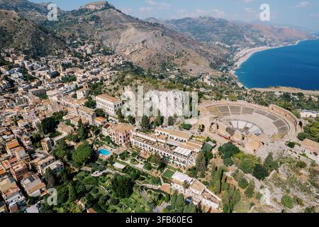Luftaufnahme von Taormina mit dem antiken griechischen Theater und der Küstenlinie Stockfoto