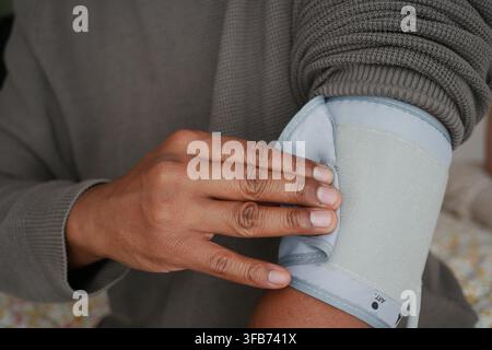 Person überprüft den Blutdruck zu Hause Stockfoto