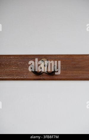 Holzregal mit Metallgarderobenhaken auf weißem Hintergrund Stockfoto