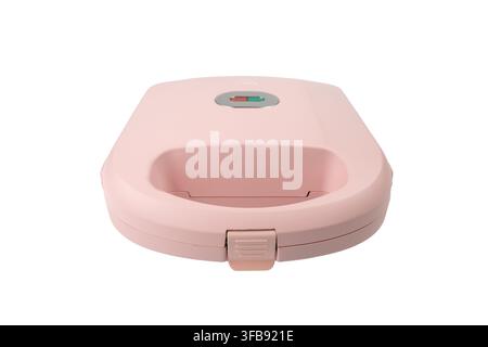 Ein geschlossener rosa Sandwich-Toastmaker wird aus einem niedrigen Frontwinkel gezeigt, wobei sein abgerundeter Körper und der vordere Verschlussriegel auf Weiß hervorgehoben werden. Stockfoto