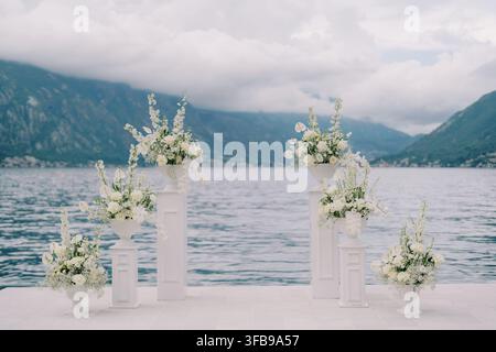 Eleganter Hochzeitsbogen mit weißen Blumen auf dem Pier von Kotor Bay Stockfoto
