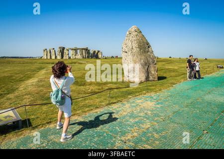 Stonehenge in Wiltshire, Britanniens bekanntestes prähistorisches Denkmal, an einem sonnigen Frühlingstag. Besucher, die posieren und Fotos machen. Stockfoto