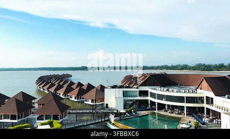 SEPANG, MALAYSIA - 15. MAI 2024: Ein erhöhter Blick auf Überwasser-Chalets, den Hauptresortkomplex und einen Swimmingpool in Sepang, Malaysia. Stockfoto