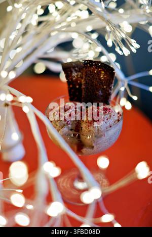 Schokoladenbrownie und Eisdessert mit festlichen Lichterketten Stockfoto