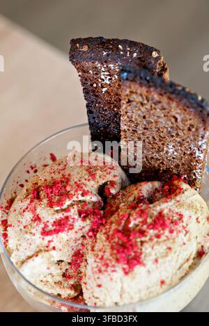 Stück Schokoladenkuchen mit Vanilleeis und roten Streuseln auf weißem Teller Stockfoto