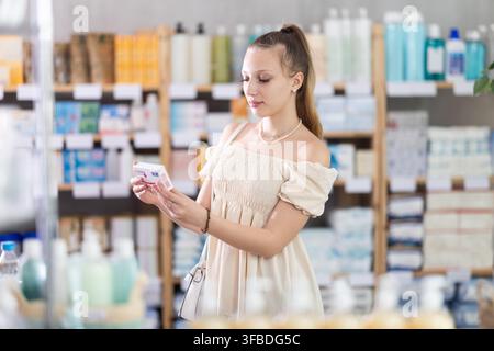 Junge Frau in wunderschönem Kleid, die Paracetamol wählt Stockfoto