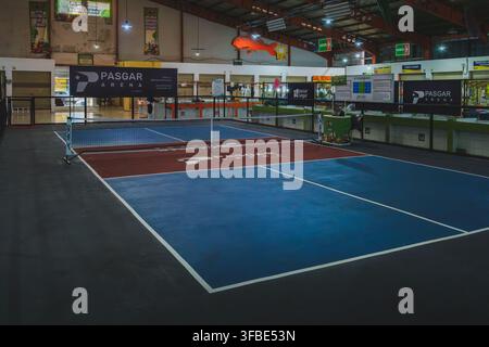 Balikpapan, Indonesien - 25. Juli 2026. Ein leerer Hallen-Pickleballplatz mit blauen und roten Oberflächenmarkierungen. Stockfoto