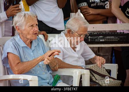 Ältere Frauen sitzen und sehen sich Vorführungen beim El Carnavalito in Ciego de Ávila, Kuba, am 21. August 2026 an. Stockfoto