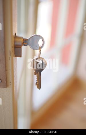 Schlüssel, die an einem Türschloss in einem Haus hängen Stockfoto