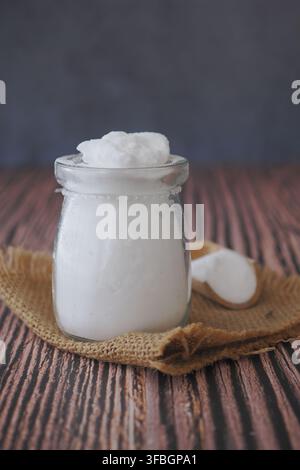 Backpulver in einem kleinen Glasgefäß auf einem Holztisch Stockfoto