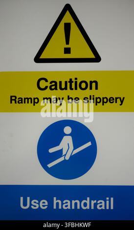 Vorsicht, die Rampe kann rutschig sein, nutzen Sie das Geländer, Schild, Warnung, gelb, schwarz, weiß, blaue Beschriftung Stockfoto