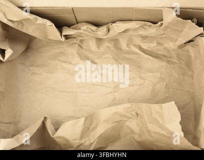 Offene leere rechteckige braune Pappschachtel für den Transport und die Verpackung von Waren, Ansicht von oben. Unten liegt ein Stück braunes Papier Stockfoto