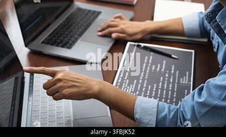 Programmierer oder Softwareentwickler, die neue Linien des Codes eingeben, Codiertechnologien, die an hölzerner industrieller Innenraumarbeitsplatz-Station arbeiten Stockfoto